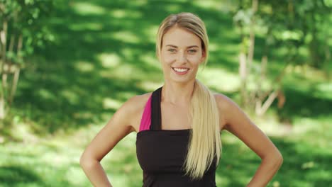 smiling woman training squat exercise in city park. woman doing warm up exercise