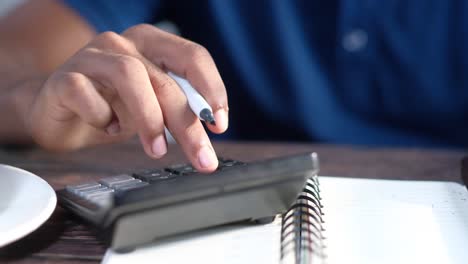 person using a calculator and pen