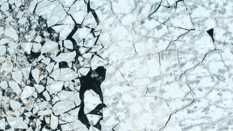 aerial fly over view of cracked ice floes floating in the sea