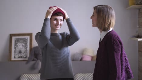 two woman friends have fun together and fitting cap. female friends