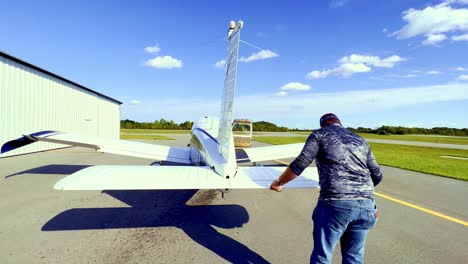 private-pilot-checks-wing-flaps-during-preflight-inspection-of-piper-cherokee-180-prior-to-flight