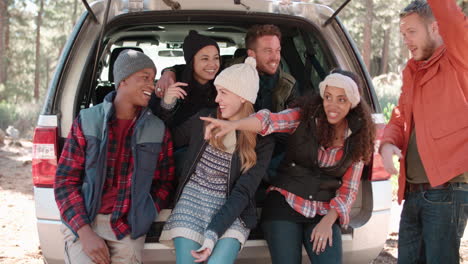 Friends-sit-talking-in-the-open-back-of-a-car-before-a-hike