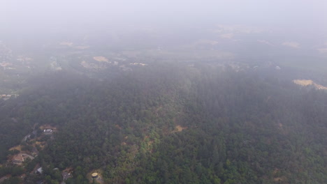 Aerial-orbit-around-forest-covered-hill-in-California,-USA