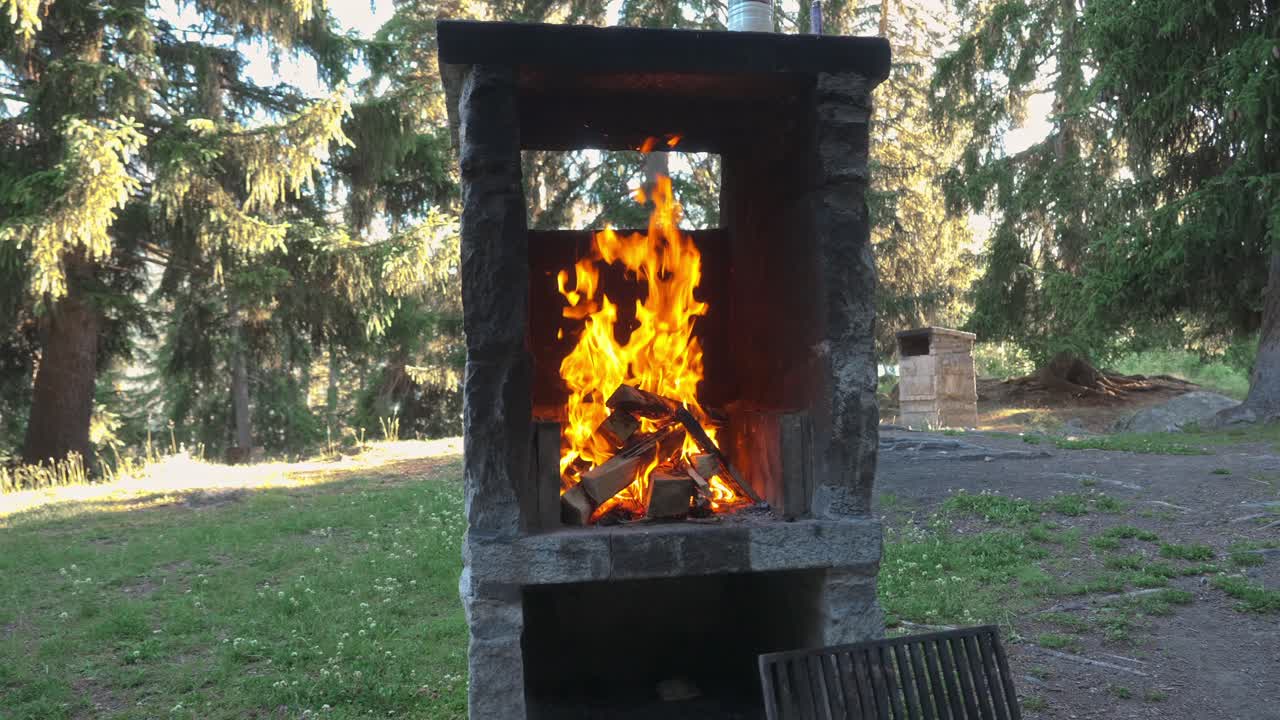 Fire burning in outdoor stone fireplace, slow-motion shot of flames rising