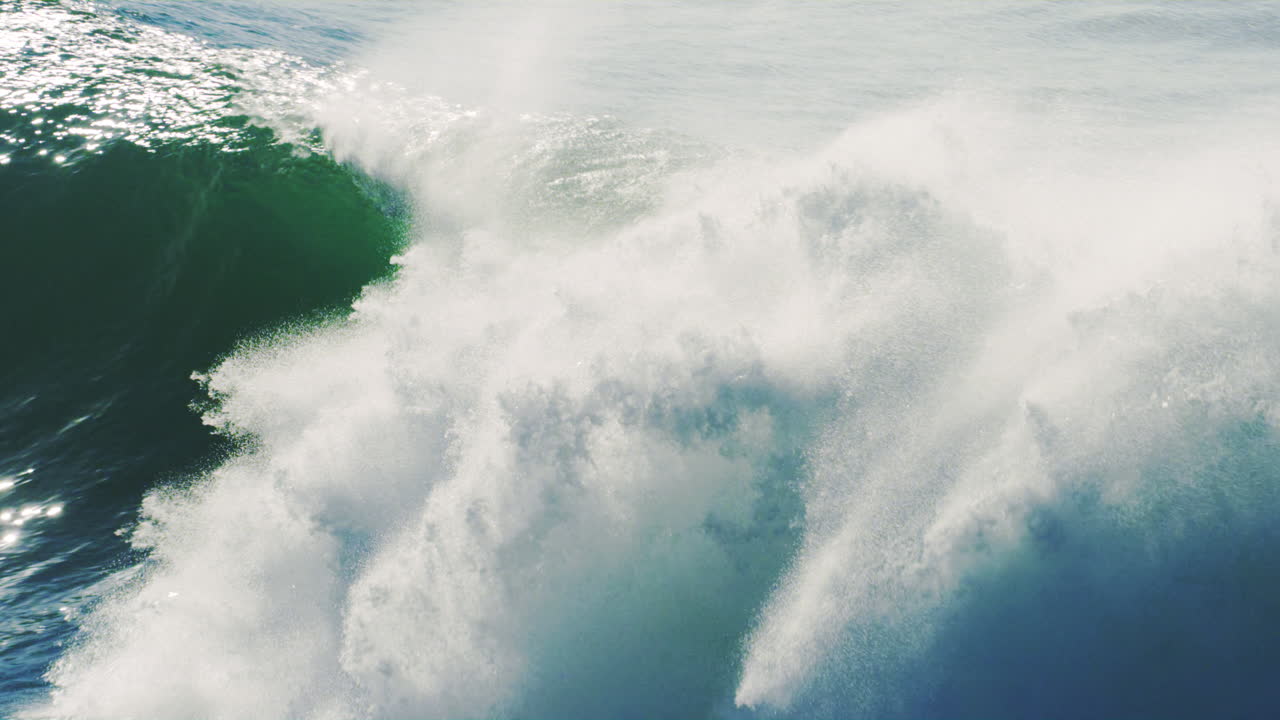 Silhouette of surfer quickly dropping into huge barrel in slow motion with ocean spray mist over top as they emerge popping over the lip