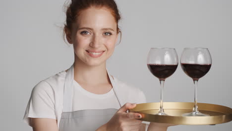 Redheaded-waitress-in-front-of-camera-on-gray-background.