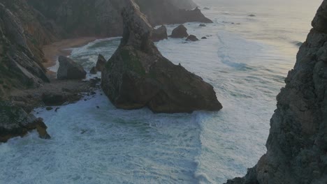 Toma-Aérea-Reveladora-De-La-Playa-De-Ursa-En-Portugal-Con-Olas-Que-Alcanzan-Entre-Rocas-Y-Acantilados.