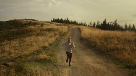 Fitter-Kerl,-Der-Marathon-In-Der-Berglandschaft-Läuft.-Starker-Mann-Joggt-Auf-Schmutziger-Straße