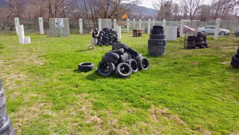 paintball player jumps over the obstacles of the battle ground