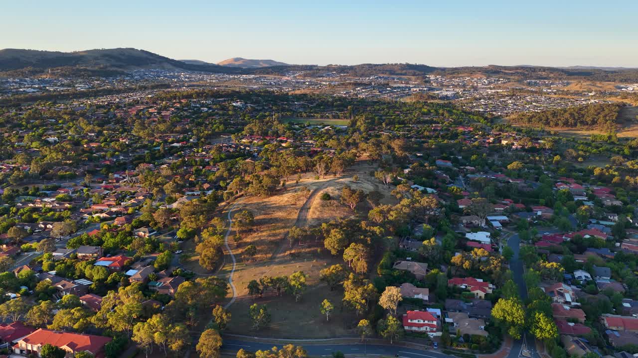 Un ampio scatto aereo riprende un quartiere periferico e un parco a Canberra durante l'ora d'oro