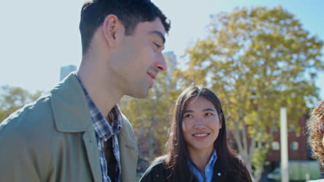 company of coworkers chatting and smiling outdoors after work