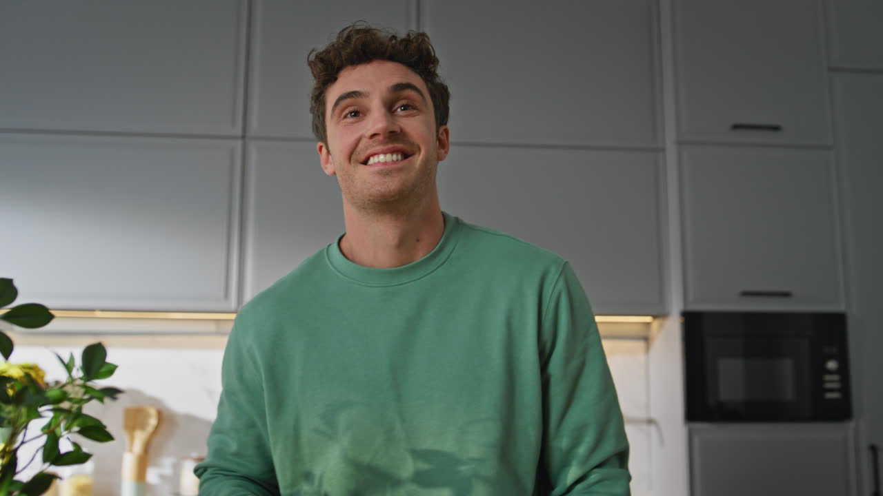 Happy guy cleaning kitchen closeup. Smiling man protective gloves wiping counter