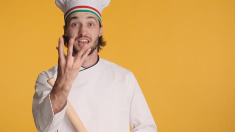 caucasian chef in front of camera on yellow background.