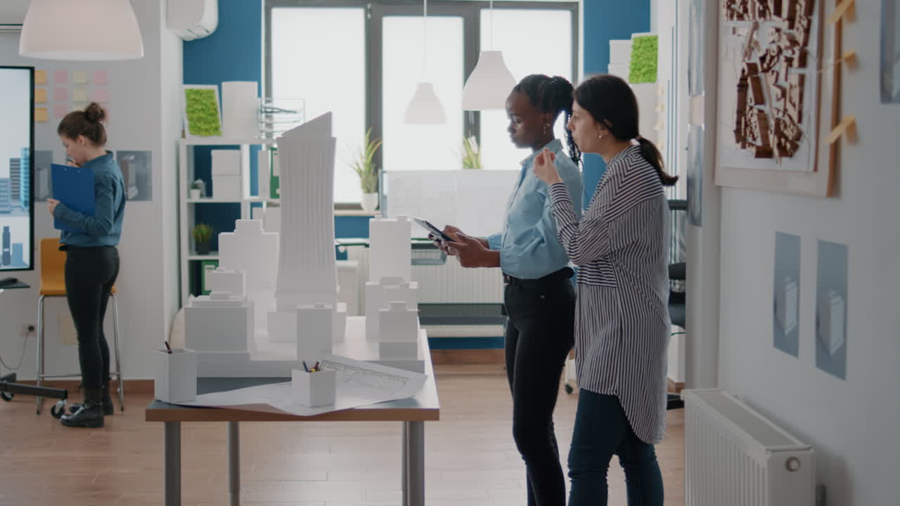 Architects discussing building model in office