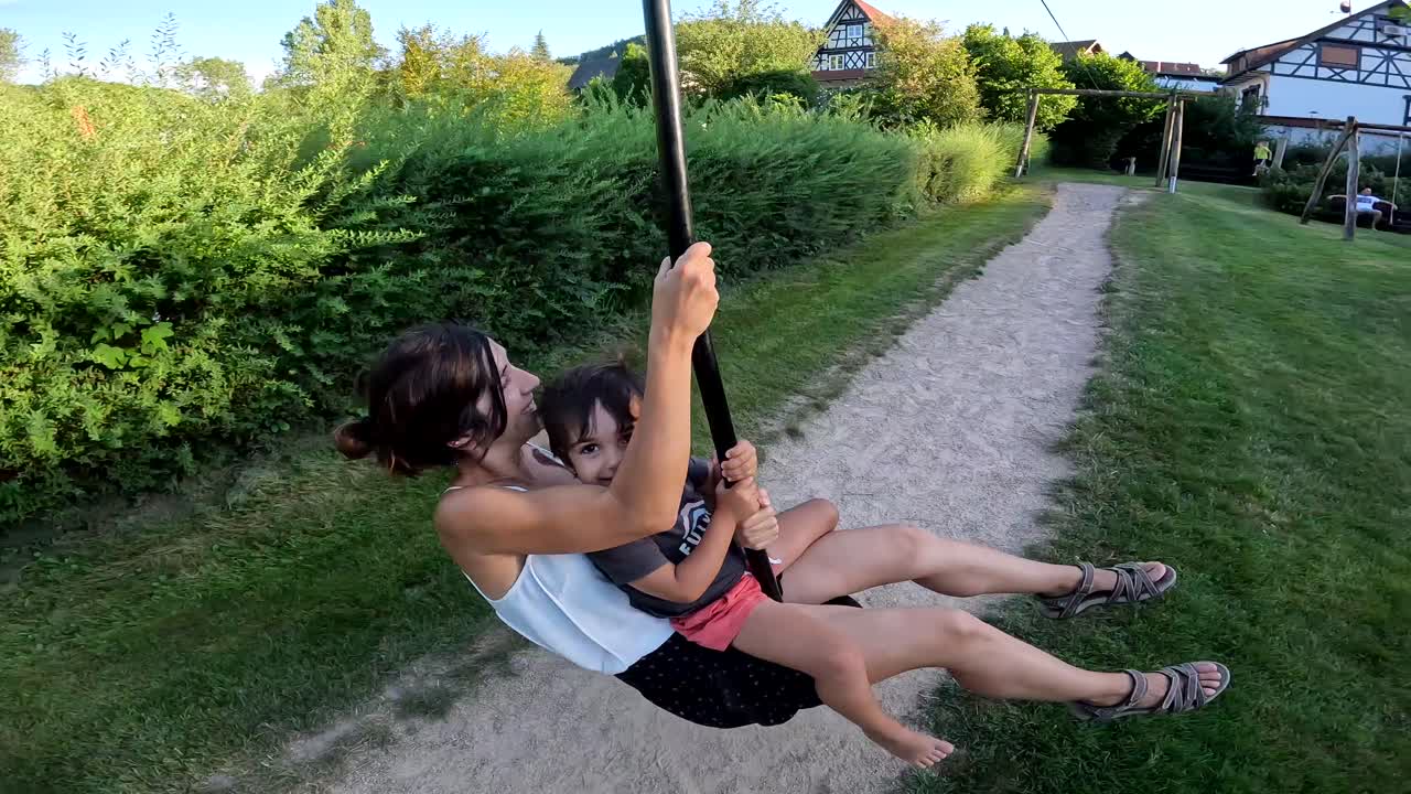 Mujer y niño tirándose en tirolina en un parque