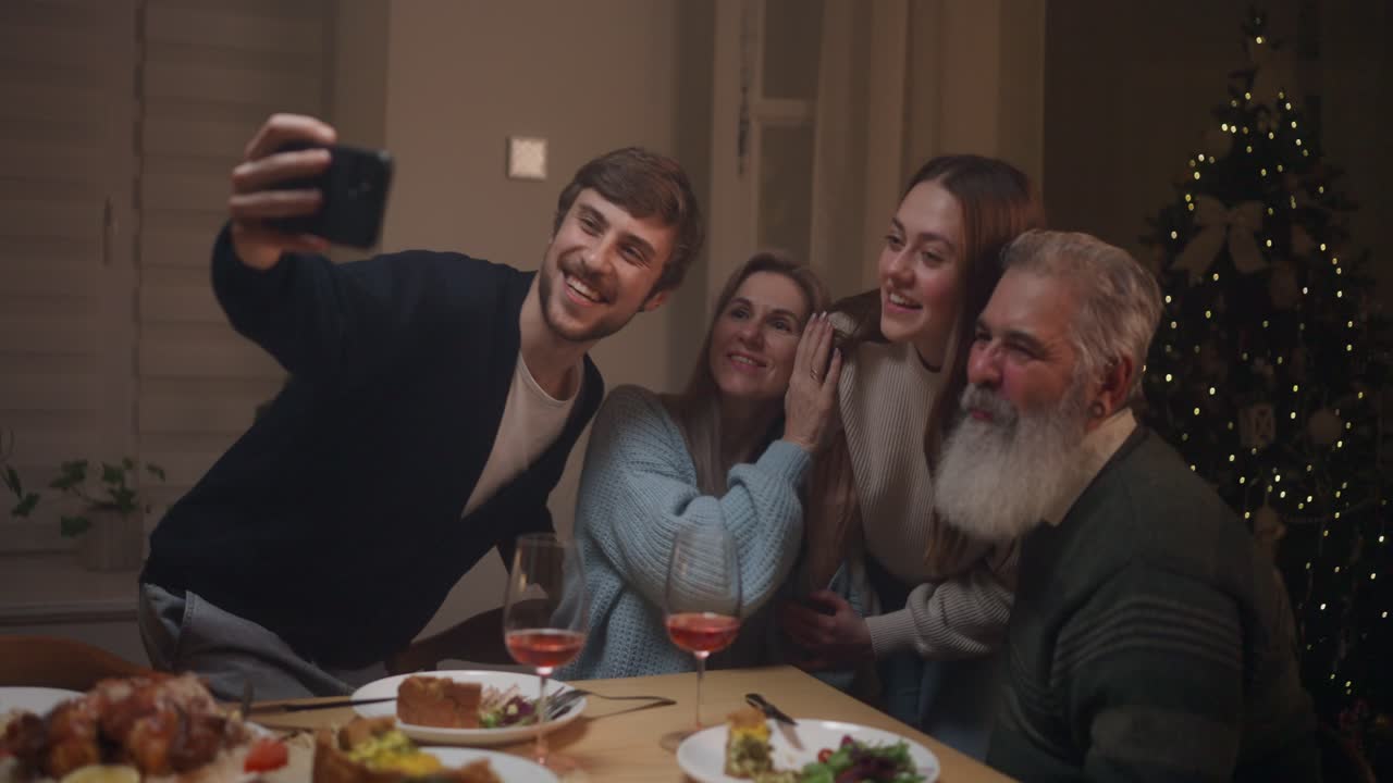 Family gathering taking photos during Christmas dinner