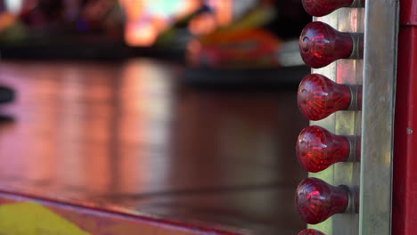 Close-up-of-Blinking-Red-Lights-while-people-are-having-fun-driving-Bumper-Cars-at-the-Fun-Fair