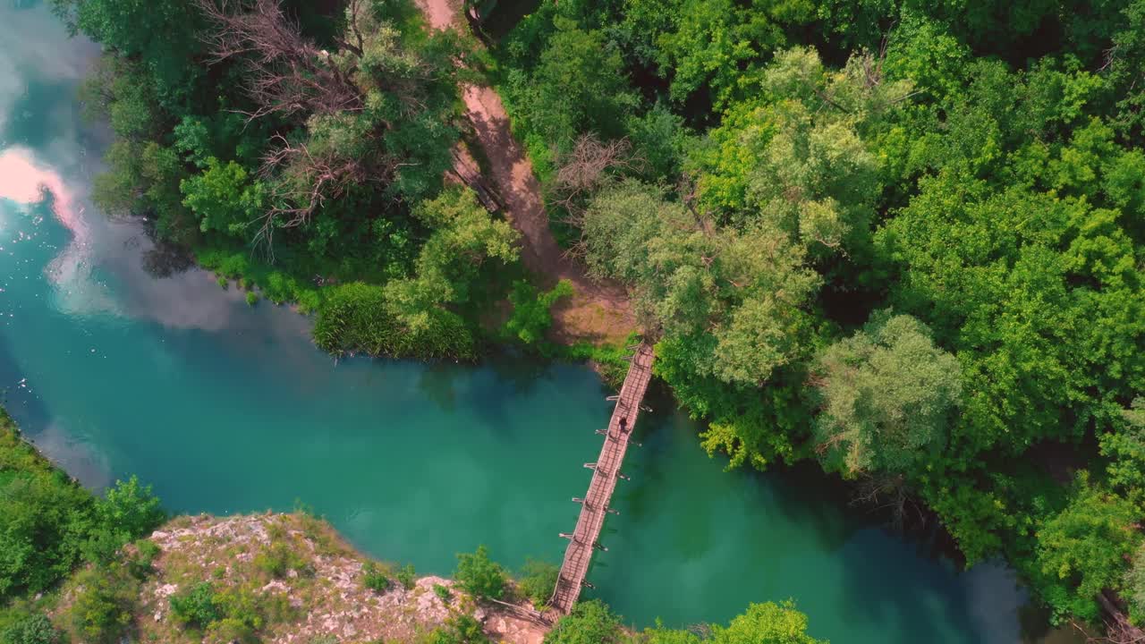 Vista aerea del fiume Panega con un ponte che lo attraversa e nuvole che si riflettono nell'acqua