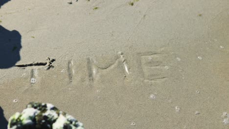 word time written on sand washed away by waves of ocean sea water. loss life