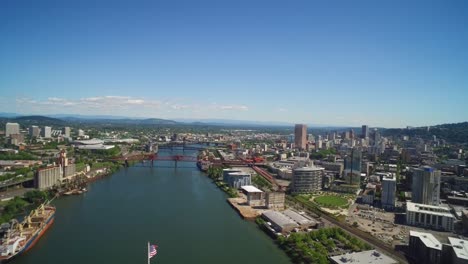 aerial with the american flag soaring over portland, oregon's skyline and the willamette river