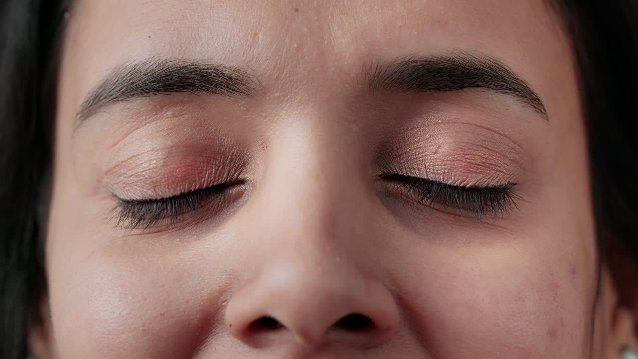 Macro shot portrait of authentic indian woman blinking in front of camera