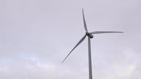 Solo-Windkraftanlage-Dreht-Sich-Vor-Bewölktem-Himmel-Und-Erzeugt-Erneuerbaren-Strom