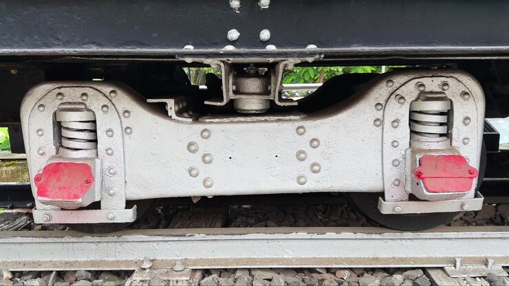 Primo piano con carrellata da sinistra a destra del gruppo sospensione e bilanciere sotto una locomotiva a vapore conservata. Solo per uso editoriale