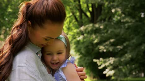 Happy-Mother-with-Little-Daughter-Playing-at-Park.family,-motherhood-and-people-concept-happy-mother-with-little-daughter-playing-at-summer-park-or-garden