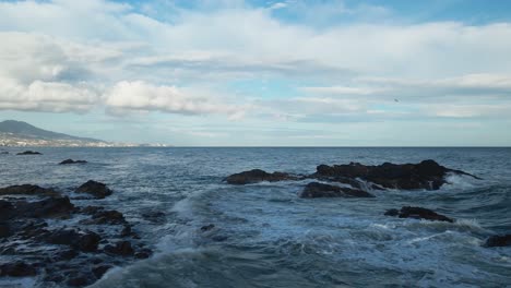 Aerial-moving-forward-at-a-rocky-coastline-near-Fuengirola,-south-of-Spain