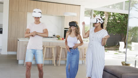 young asian man and two young biracial women enjoy virtual reality at home