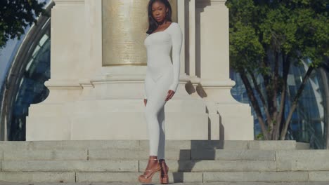 Una-Joven-Vestida-Con-Un-Traje-Blanco-Disfruta-De-Un-Día-En-La-Ciudad,-Con-Castillos-Al-Fondo