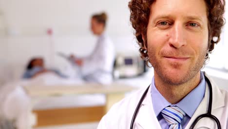 Doctor-smiling-at-camera-in-the-ward