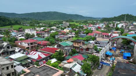 overhead drone shot of idyllic island town with lush jungles and mountainous background