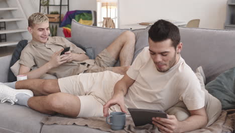 gay couple spending weekend on sofa at home