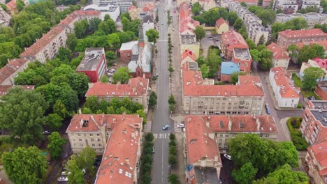 Red-rooftops-and-streets-of-Klaipeda-city,-aerial-drone-view