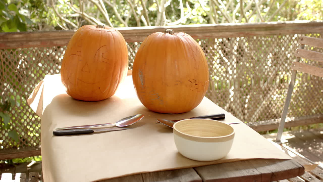 Pumpkins on table with carving tools ready for Halloween decoration on a porch