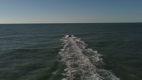 Aerial-shot-of-a-boat-sailing-into-the-ocean