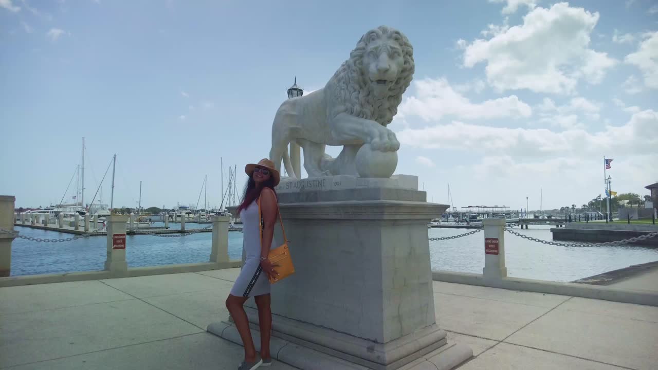 Una ragazza che indossa un mini abito di pizzo bianco esplora i cortili nascosti della Città Vecchia, St. Augustine.