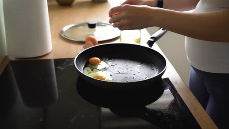 Mujer-Embarazada-Rompiendo-Huevos-En-Una-Sartén-Caliente-Para-Preparar-El-Desayuno-Por-La-Mañana-En-Casa