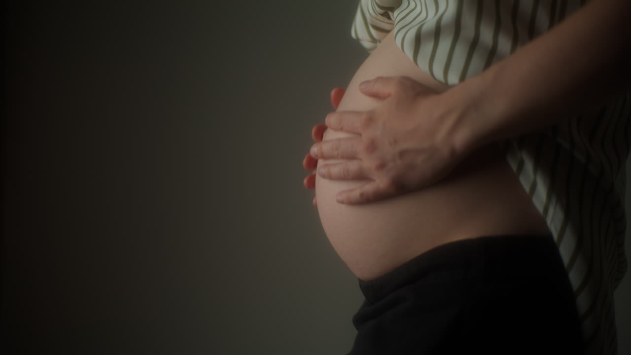 Donna incinta accarezza la pancia