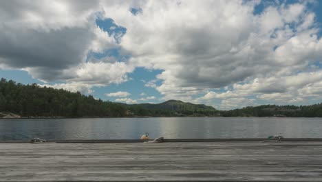 dramatic time lapse over lake pier, moody skyscape in countryside