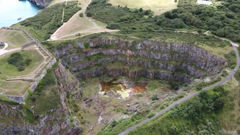 Cantera-De-Piedra-Caliza-Abandonada-En-Brixham,-Inglaterra,-Inclinación-Aérea-Hacia-Arriba