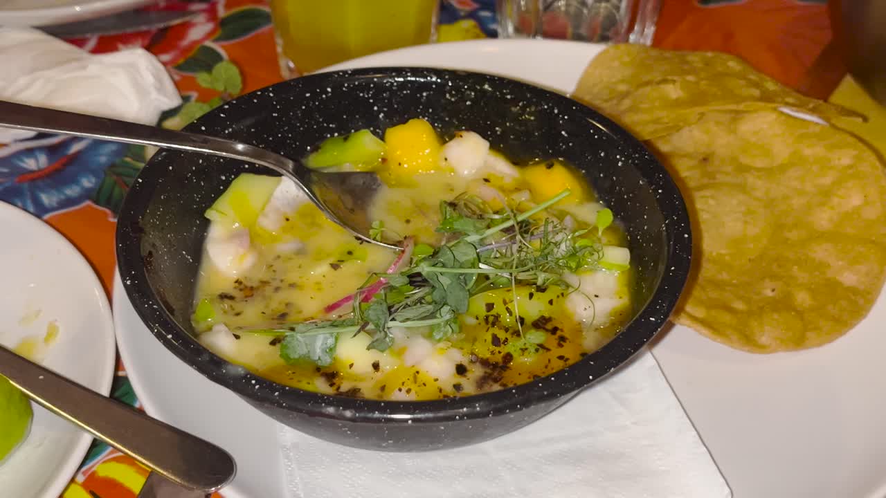 un cuenco vibrante de ceviche con camarones, mango, aguacate y hierbas frescas, servido con tortillas crujientes. un refrescante plato de mariscos lleno de sabor, perfecto para los amantes de la comida y la alimentación saludable.