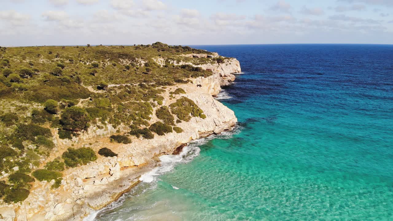 An upward panning shot showing the cliff line at the Cala Varques beach in Majorca, Spain