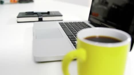 portátil con organizador personal y bolígrafo en la mesa
