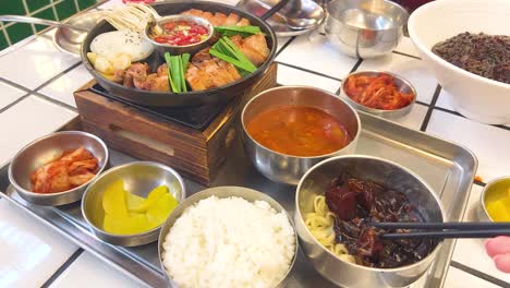 plato de comida coreana con carne de cerdo, arroz, fideos y kimchi
