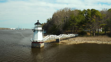 Scenic-Aerial-Footage-of-Doubling-Point-Lighthouse-with-Bath-Iron-Works-visible-in-background,-Arrowsic,-Maine,-USA