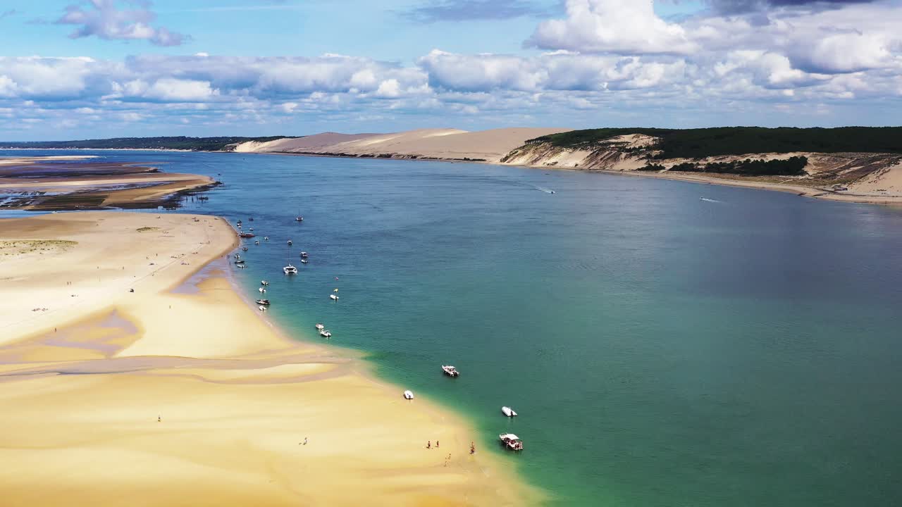Banc d'Arguin nella baia di Arcachon, Francia, con barche ancorate in fila lungo la costa sabbiosa, vista aerea dall'alto