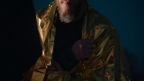 man wrapped in gold blanket