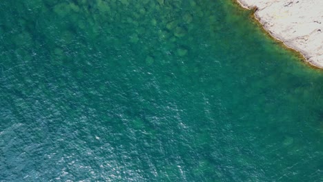 Vista-Aérea-De-Las-Tranquilas-Olas-Del-Lago-De-La-Costa-Norte-En-Un-Día-Soleado